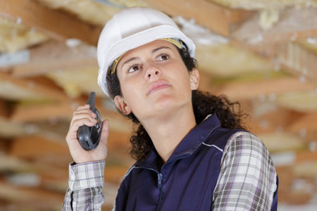 female worker relaying instructions via walkie talkieの写真素材