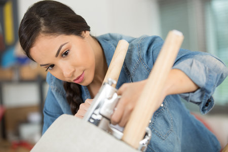 woman fixing a chair with stapleの写真素材