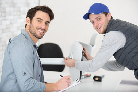 man assembling office chair under supervision