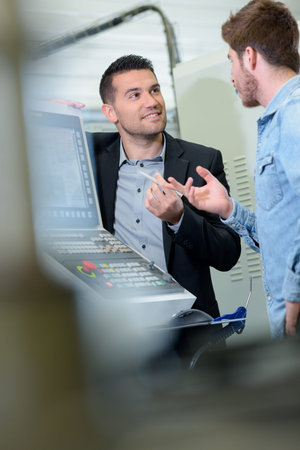 man and apprentice watching printing machine