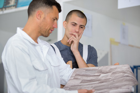 two decorators in discussion about paper wallの写真素材