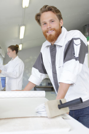 handyman applying blue for a wallpaperの写真素材