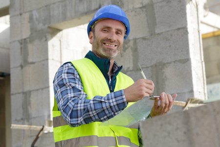 architect holding clipboard and pen on black background