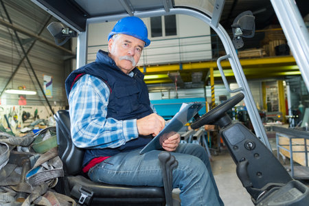 forklift driver in industrial logistics warehouseの写真素材