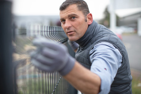 man places metal fence panelの写真素材