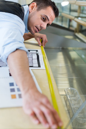 man measuring with tape measureの写真素材