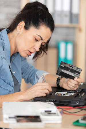 beautiful woman repairing laptop computerの写真素材