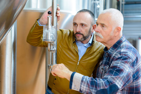 brewery workers pouring beer into a glassの写真素材