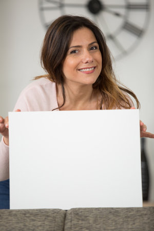 happy woman looking at camera pointing at bannerの写真素材