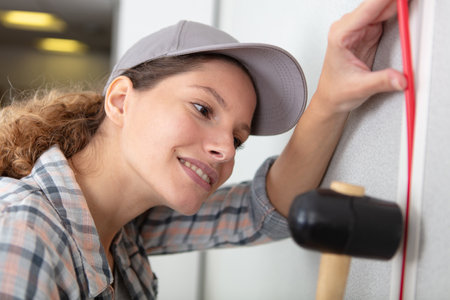 tradeswoman installing electrical wiring in buildingの写真素材