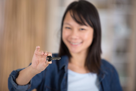 cute asian girl showing home residence keysの写真素材