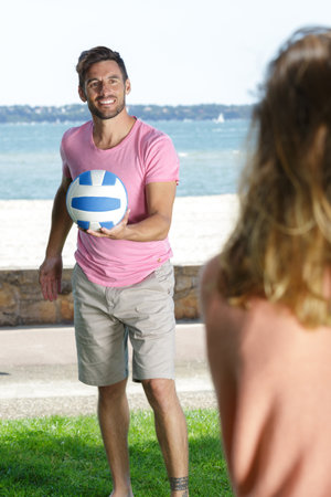 couple playing volleyball in the parkの写真素材