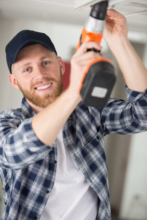 man is drilling the ceilingの写真素材