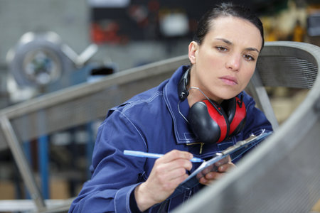 worker holding check list and writing notes working in warehouseの写真素材