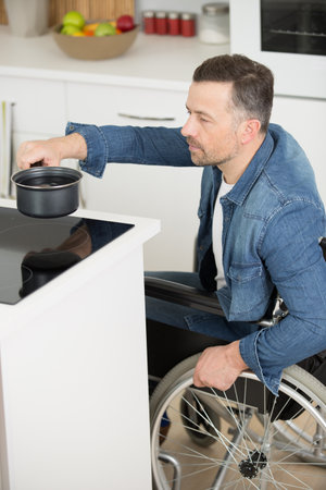 disabled man in wheelchair in the kitchenの写真素材