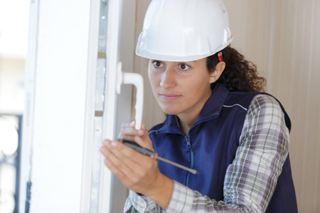 young woman builder working using a screwdriverの写真素材