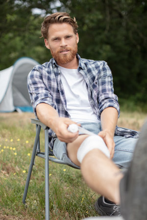 man putting bandage on his legの写真素材