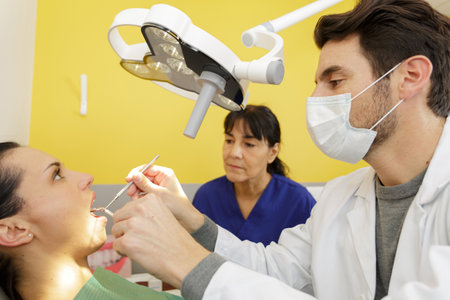 handsome man dentist with female patientの写真素材