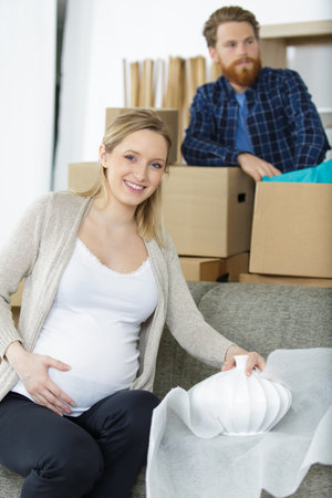 young couple moving to new flat with fragile thingsの写真素材