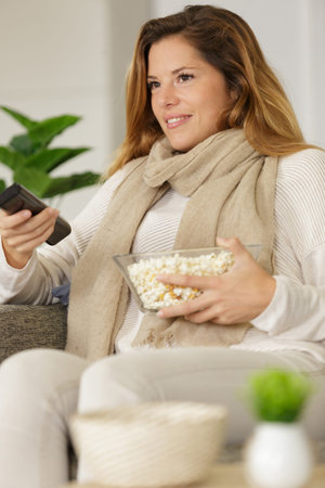excited girl watching tv eating popcorn