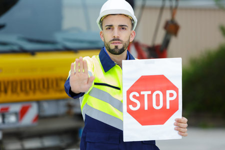 tradesman holding a stop sign