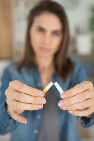 woman breaks a cigarette with her fingersの写真素材