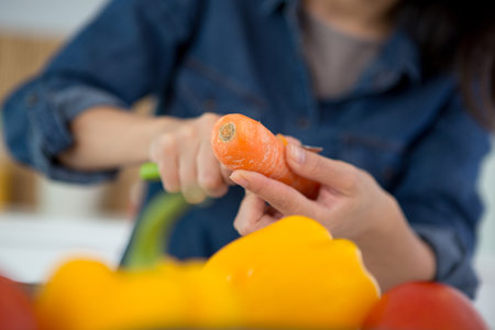 cropped image of woman peeling a carrotの写真素材