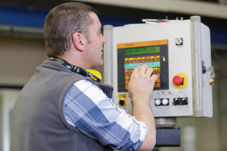 male worker stood operating electronic factory controls