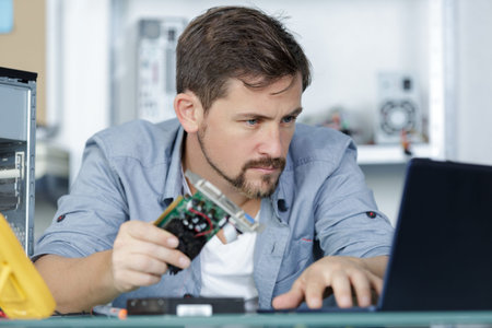 man repairman fixes a computer