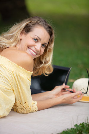 a smiling young girl with laptop outdoorsの写真素材