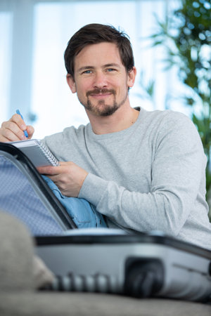 man writes down what to take with himの写真素材