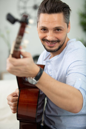 mature trendy guy playing the guitarの写真素材