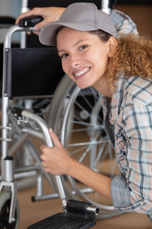 woman making an adjustment on a wheelchairの写真素材
