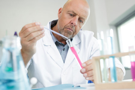 mature lab worker conducting a chemical experiment