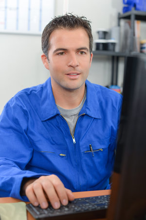 Manual worker at his computerの写真素材