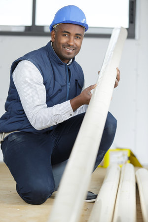 builder in a property holding a length of plasticの写真素材