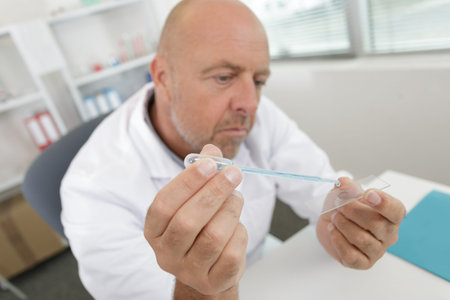 mature man using a test tube and pipette