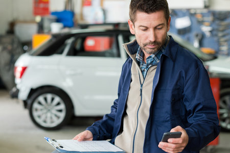 mechanic repairing motor boats and phone at customerの写真素材