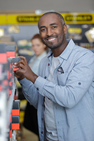 handsome taking shoe box from shelf in storeの写真素材