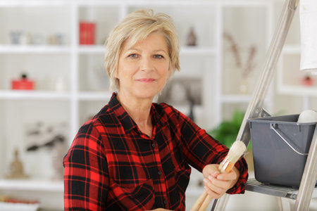 mature woman redecorating her homeの写真素材