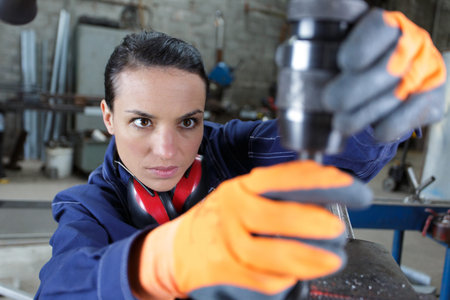 handywoman using a drilling machine