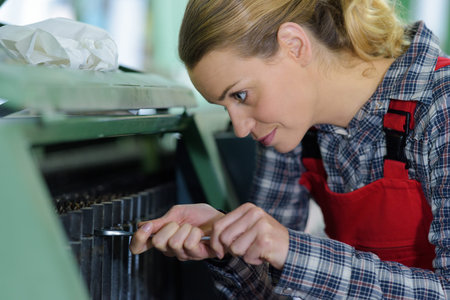 strong and worthy woman fixing a machine