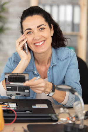 young female engineer is focused on the repair of laptopの写真素材
