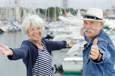 elderly couple arms open on a portの写真素材