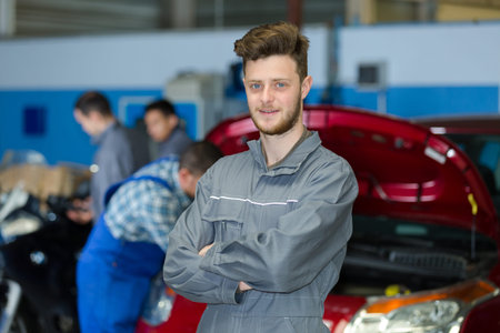 portrait of young apprentice mechanic in car garageの写真素材
