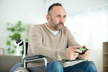 serious disabled man playing computer games during rehabilitationの写真素材