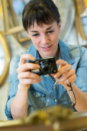 portrait of young woman holding cameraの写真素材