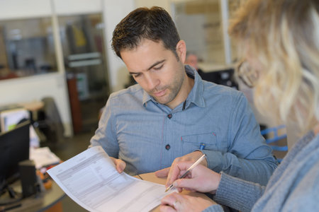 man writing on paper in office