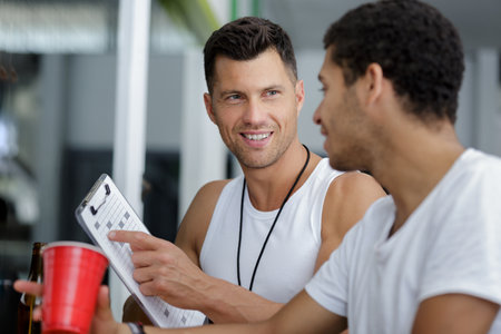 trainer helping man on her exercises routinesの写真素材