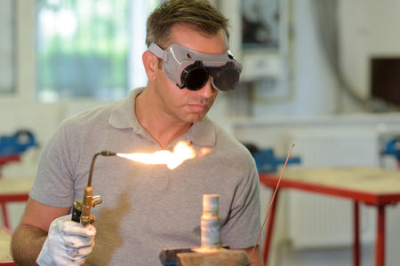 worker cutting pipe with a flame torch cutter